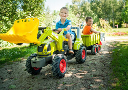 Spielende Kinder auf einem Trecker mit Anhänger