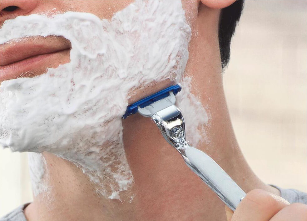 Mann rasiert sich