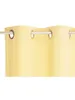 A close-up of a yellow curtain with grommets hanging from a curtain rod. Produktbild-Vorschau