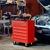A red tool chest with tools on top, next to a car with its hood open in a workshop. Produktbild-Vorschau