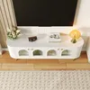 A white TV stand with glass doors and gold accents, placed in a living room setting. Podgląd zdjęcia produktu