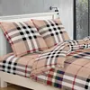 A close-up view of a bed with plaid patterned bedding and pillows. Náhľad obrázku produktu