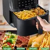 A hand is pulling out the basket of an air fryer filled with french fries and chicken nuggets. Below are images of different foods being cooked in an air fryer with cooking times and temperatures. Produktbild-Vorschau