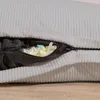 A close-up view of a light gray corduroy beanbag with a zipper partially open, revealing the filling. Voir les images du produit