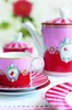 A tea set with a cup, saucer, teapot, and sugar bowl, decorated with stripes and bird motifs. Produktbild-Vorschau
