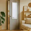 A mirror hanging on a door in a room with a plant and a bookshelf. Anteprima dell’immagine prodotto