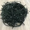 A tangled pile of green LED string lights on a light wooden floor. Produktbild-Vorschau
