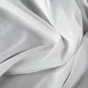A close-up view of white fabric, likely a curtain or sheer textile, with soft folds and textures. Produktbild-Vorschau