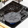A pancake pan with smiley faces is on a gas stove with a blue flame. Náhled obrázku produktu