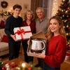 A family is exchanging gifts during Christmas, with a Christmas tree in the background. Podgląd zdjęcia produktu