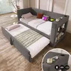 A grey upholstered daybed with a pull-out trundle bed, set up in a room with soft lighting and decor. Anteprima dell’immagine prodotto