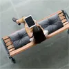 A person sits on a bench with cushions, using a tablet. Náhled obrázku produktu