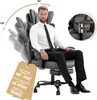 A man is sitting in a black office chair, demonstrating its features. Produktbild-Vorschau