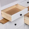 A close-up view of an open drawer in a white wooden cabinet, revealing the unfinished wood interior. Náhľad obrázku produktu