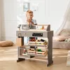 A young boy is playing with a wooden toy shop counter filled with toy food items. Anteprima dell’immagine prodotto