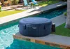 An inflatable hot tub sits on the edge of a swimming pool. Produktbild-Vorschau
