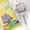 A bag of cat litter and a scoop filled with cat litter are shown on a white surface. Podgląd zdjęcia produktu