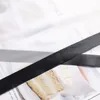 A close-up view of black and gray ribbons laid over a magazine spread featuring a cake. Produktbild-Vorschau