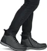 A person wearing dark jeans and gray boots. Produktbild-Vorschau