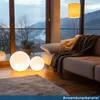 A modern living room with a sofa, a floor lamp, and two glowing sphere lights. Produktbild-Vorschau