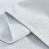 A close-up view of a folded gray fabric with a herringbone pattern. Produktbild-Vorschau