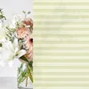 A bouquet of white and pink flowers in a glass vase, with a striped overlay on the right side. Produktbild-Vorschau