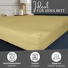 A close-up of a beige fitted sheet on a bed, with marketing icons and text at the bottom. Produktbild-Vorschau