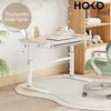 A child's desk setup in a room with a bookshelf and chair. Produktbild-Vorschau