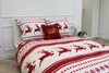 A Christmas-themed duvet cover and pillow set with reindeer and snowflake patterns is displayed on a bed. Podgląd zdjęcia produktu