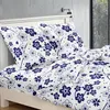 A bed with white bedding featuring a blue floral pattern. Produktbild-Vorschau