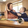 A mother and child are high-fiving while sitting at a table with school supplies. Produktbild-Vorschau