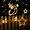 Decorative lights in the shape of stars and a crescent moon hang against a dark background, with a blurred white fence visible below. Náhľad obrázku produktu