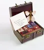 An open trunk filled with small, decorative books and a note addressed to Harry Potter. Produktbild-Vorschau