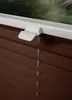 A close-up view of a brown blind with a white clip mechanism attached to the top. Produktbild-Vorschau