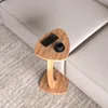 A small wooden side table with a phone and a cup of coffee on it, placed next to a sofa. Náhled obrázku produktu