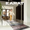A family is moving into a new home, with the child excitedly running ahead on a rug. Náhled obrázku produktu
