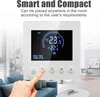 A hand is shown pressing a button on a smart thermostat, which is mounted on a wall in a living room setting. Podgląd zdjęcia produktu