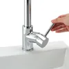 A hand is shown turning the handle of a chrome kitchen faucet mounted on a white sink. Produktbild-Vorschau