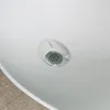 A close-up view of a white sink drain with a metal grate. Produktbild-Vorschau
