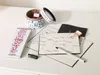A desk with stationery items including notebooks, pens, and a roll of tape. Podgląd zdjęcia produktu