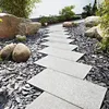 A garden path made of stepping stones surrounded by dark gravel and large rocks. Produktbild-Vorschau