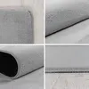A collage of four close-up images showing different angles and details of a round, silver rug. Náhled obrázku produktu