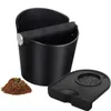 A coffee knock box, tamping mat, and coffee grounds are displayed on a white background. Produktbild-Vorschau