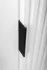 A close-up shot of a black handle on a white cabinet door. Podgląd zdjęcia produktu