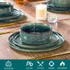 A table setting with green stoneware plates and bowls, gold cutlery, and a candle. Voir les images du produit