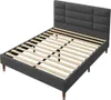 A gray upholstered bed frame with a slatted base and a padded headboard, shown from a side angle against a white background. Produktbild-Vorschau