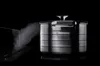 A stainless steel pot with steam rising from it, placed on a dark surface. Produktbild-Vorschau