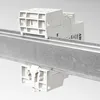 Two white electrical components are mounted on a metal rail against a white background. Produktbild-Vorschau