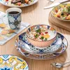 A table setting with a breakfast bowl, mug, and plates, all featuring a bohemian-inspired pattern. Náhled obrázku produktu