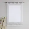 A white sheer curtain with a floral embroidered hem is shown hanging in a window. Produktbild-Vorschau